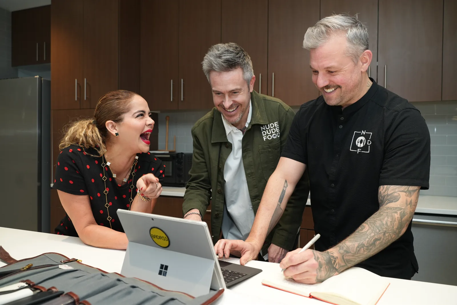A Nude Dude Food chef shares ideas with a participant in a kitchen